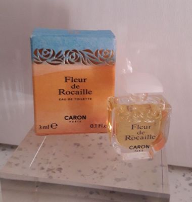un flacon de parfum posé sur un comptoir à côté d'une boîte de parfum