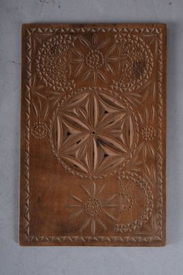 une image représentant une plaque en bois ornée d'un motif floral