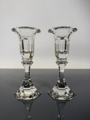 pair of clear glass candlesticks on a black table