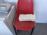 a red chair with a piece of pizza on it