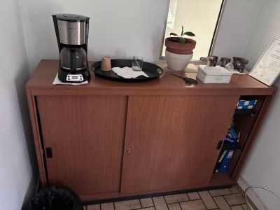 une cafetière posée sur un meuble en bois