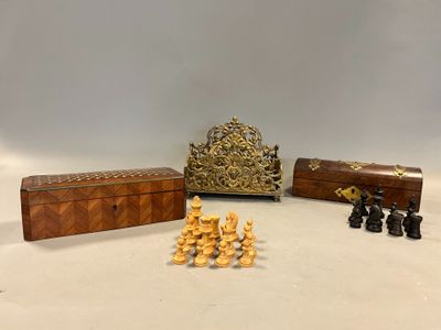 Plusieurs pièces d'échecs sont posées sur une table, à côté d'une boîte en bois.