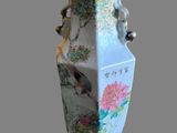 un vase avec un oiseau sur un support