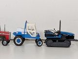 many toy tractors lined up in a row on a white surface