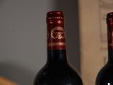 two bottles of wine sitting on a table next to each other