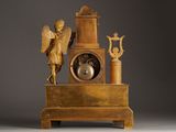 a gold clock with an angel on top of it