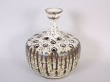 a white and brown vase sitting on a white surface