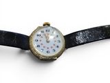 a watch that is sitting on a black leather strap