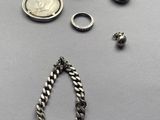 several different types of jewelry including a necklace, ear rings, and a coin