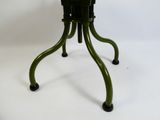 une petite table à deux pieds avec un plateau vert