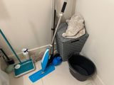a mop, bucket, broom, and bucket on the floor