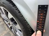 a hand that is holding a ruler next to a car