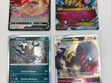 quatre types différents de cartes Pokémon posées sur une table