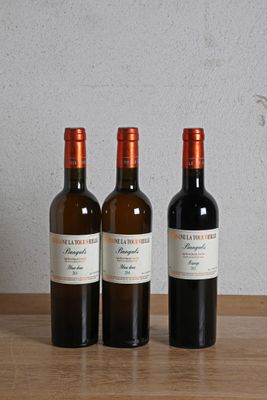trois bouteilles de vin posées sur une table en bois