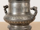 a silver vase sitting on top of a wooden table