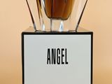 an angel perfume bottle sitting on top of a black stand