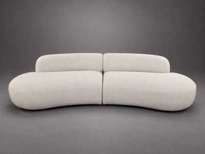 the curved sofa is made out of fabric and has a rounded shape