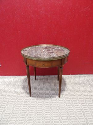 a small table with a marble top sitting on top of a carpeted floor