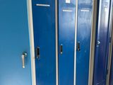 several blue lockers are lined up in a row in a public bathroom