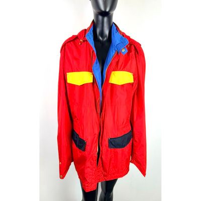 veste rouge avec des bordures bleues et jaunes sur une tête de mannequin