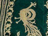 an image of a close up of a green dress with gold embroidery