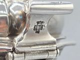 an antique silver plated tea pot with a handle on a stand