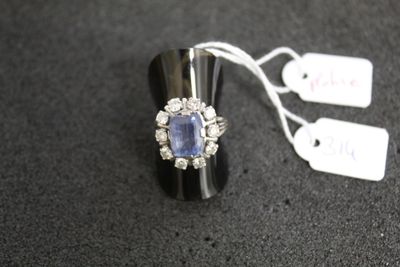 une image représentant une bague sertie d'un saphir bleu entouré de diamants blancs
