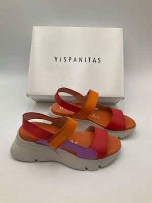une paire de sandales orange et violettes avec une boîte