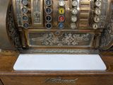 an old fashioned cash register sitting on top of a wooden table