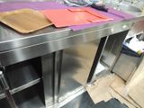 a metal counter with a cutting board on top of it