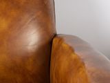 brown leather chair with armrests and foot rest in a living room