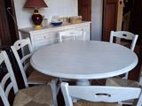 une table blanche et quatre chaises dans une pièce