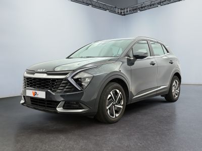 un SUV gris garé dans une grande pièce au sol noir