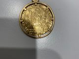 gros plan d'une médaille d'or sur une surface blanche