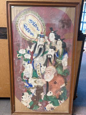 tableau encadré représentant un groupe de personnages asiatiques, exposé dans une pièce