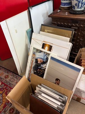 une boîte en carton remplie de photos et d'autres objets, posée par terre