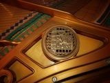a close up of a golden piano with a clock on it