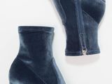 a pair of blue velvet ankle boots on a white background