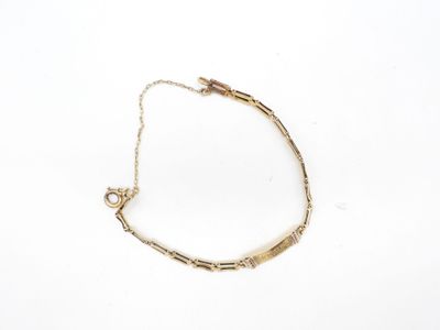 gros plan d'un bracelet en or sur une surface blanche