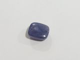 a blue sapphire stone sitting on top of a white surface