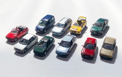 plusieurs petites voitures sont alignées sur une surface blanche