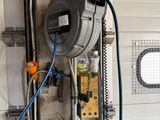 a water meter in a garage with a hose attached to it