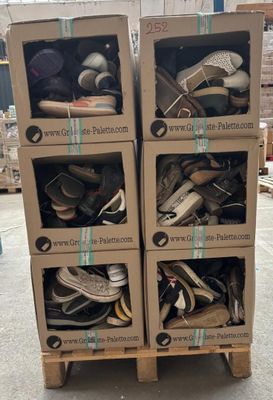 Des cartons de chaussures sont empilés les uns sur les autres dans un entrepôt