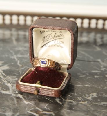 une bague dans une boîte posée sur une table, dans laquelle se trouve une bague