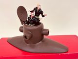 figurine of a man sitting on top of a toilet in a red box
