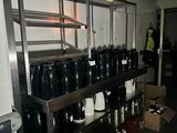 de nombreuses cafetières et tasses sur les étagères de la cuisine