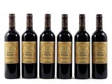 six bottles of wine are lined up on a white surface