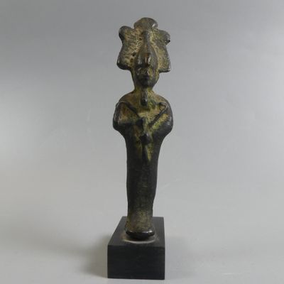 une statue en bronze représentant une femme coiffée d'une coiffe