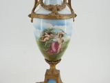 a vase with a painting on it sitting on a stand