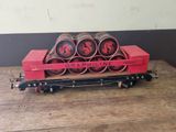 un wagon rouge sur lequel sont empilés tout un tas de rouleaux